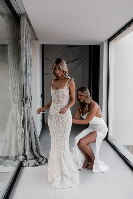 a beautiful mermaid wedding dress with embellishments and straps plus a train for a sexy and glam bridal look
