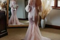 a blush off-the-shoulder mermaid wedding dress with puff sleeves and a train plus a blush wrap for the hair