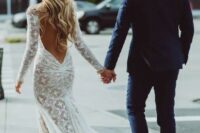 a boho lace mermaid wedding dress wiht a low back, long sleeves and a train for a sexy boho bridal look