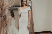 a bold and unusual one shoulder mermaid wedding dress with a layered skirt and a train is a fantastic solution to catch an eye