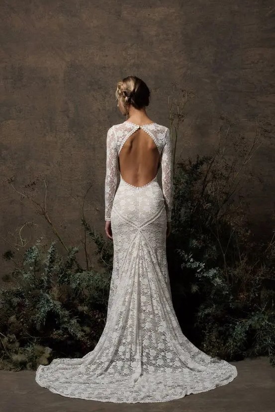 a chic boho lace mermaid wedding dress with a keyhole back, long sleeves, a high neckline and a short train is a lovely idea for a modern space