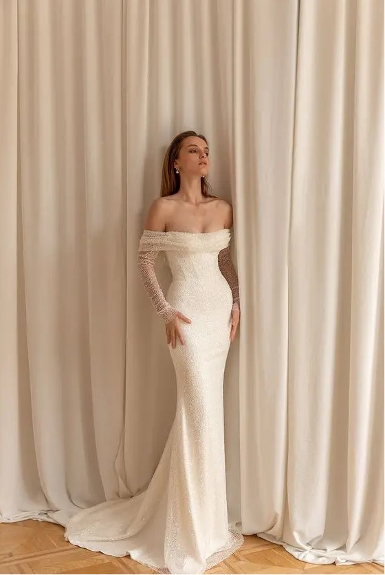 a mermaid off the shoulder fully beaded wedding dress with illusion sleeves and a train is a lovely idea for a glam bride
