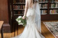 a mermaid wedding dress with lace applique, a tulle tail and spaghetti straps and a veil for a sexy and romantic bridal look