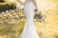 a romantic mermaid wedding dress wiht a lace bodice, a keyhole back and no sleeves, a small train and statement earrings