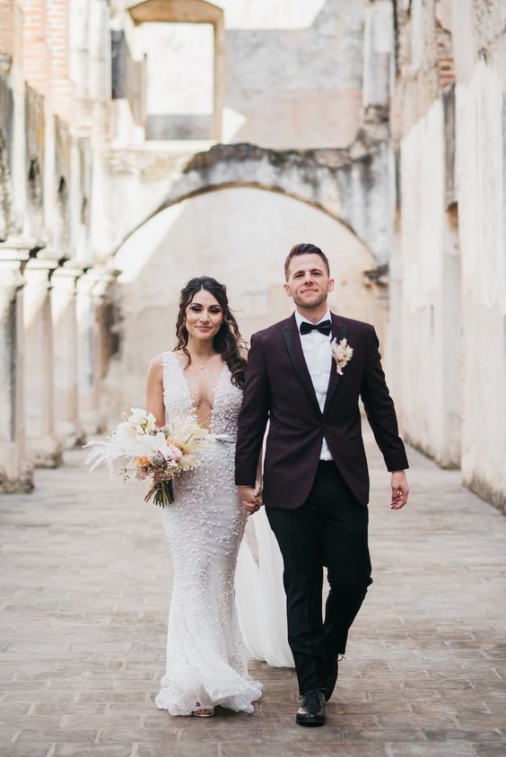 an embellished mermaid wedding dress with a covered plunging neckline and no sleeves is a chic and glam idea for a wedding
