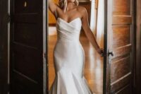 an exquisite modern strapless wedding dress with a mermaid silhouette, a draped bodice and a train is jaw-dropping
