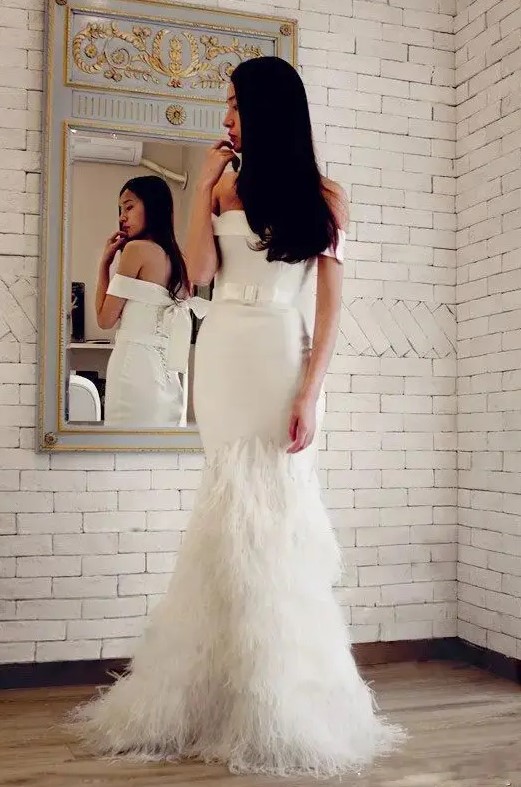 an off the shoulder mermaid wedding dress with a belt and a feathered skirt is a very sophisticated solution