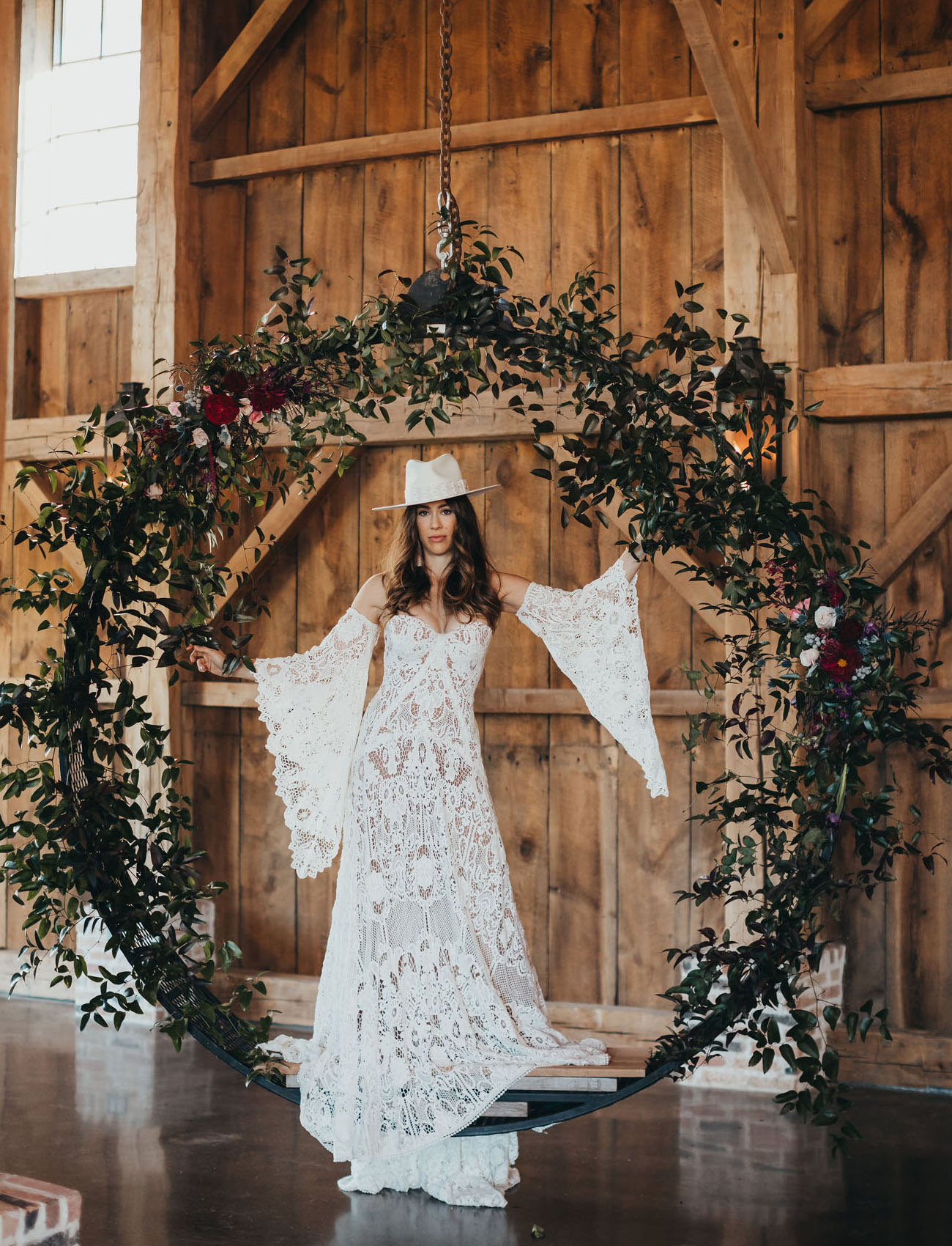 The bride was wearing a strapless boho lace wedding dress with removable sleeves and a matching hat