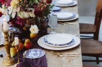 03 a moody spring tablescape with pears, gold candle holders, a purple table runner and blue porcelain