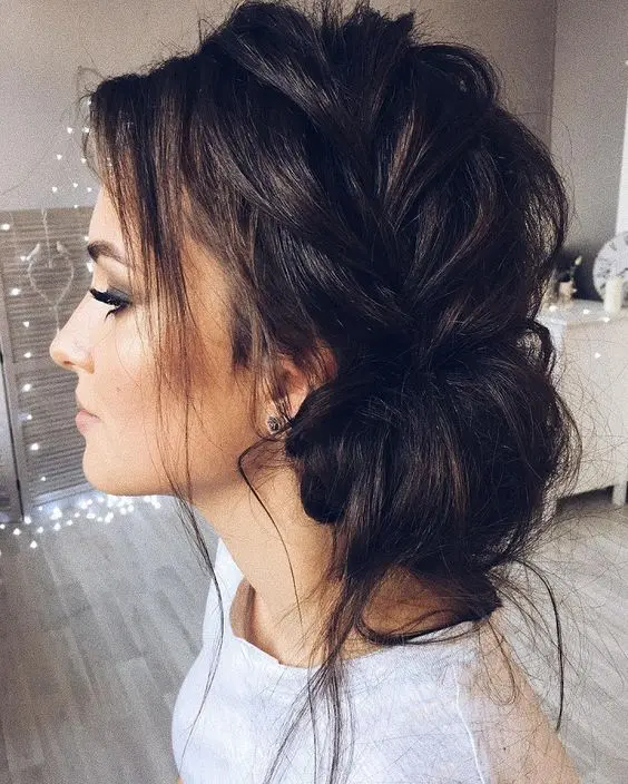 a messy side braided updo with locks down looks very modern and cool