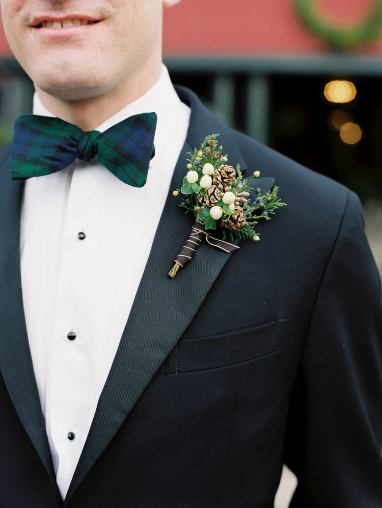 The groom was wearing a black tux with a black watch tartan bow tie and a bold boutonniere