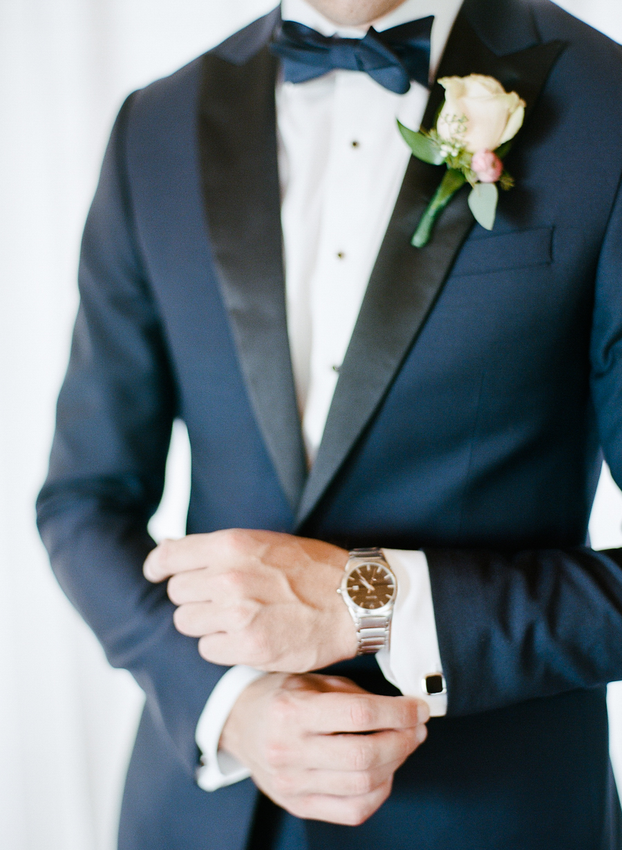 The groom was wearing a navy tuxedo with black lapels and a bow tie