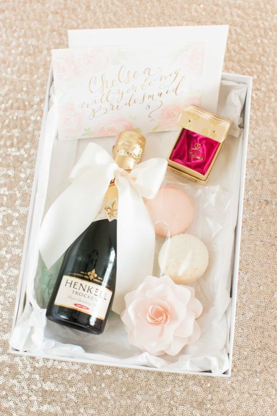 a stylish box with champagne, macarons and some jewelry plus a watercolor card