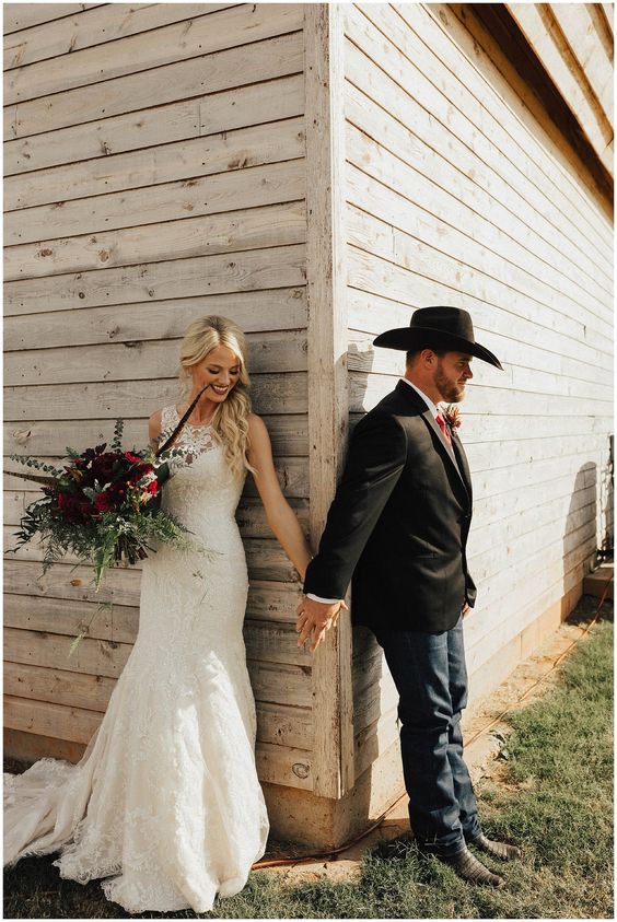 navy jeans, a black jacket, a white shirt, a bold tie and a cowboy hat for a ranch wedding