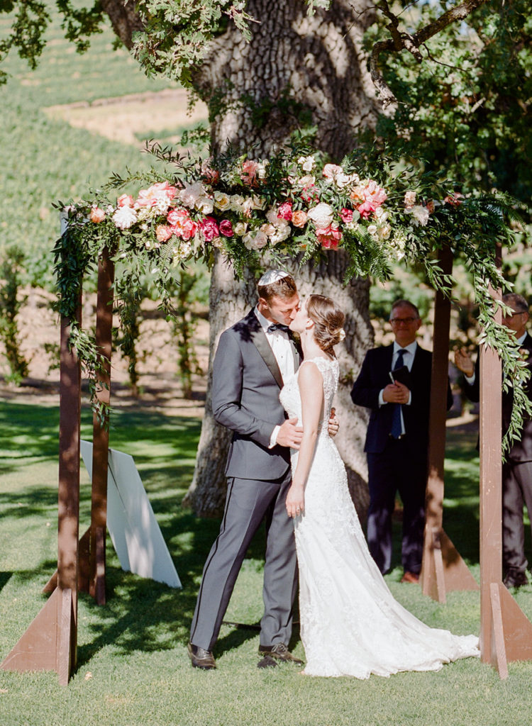 There was a lush decorated wedding chuppah with greenery and florals