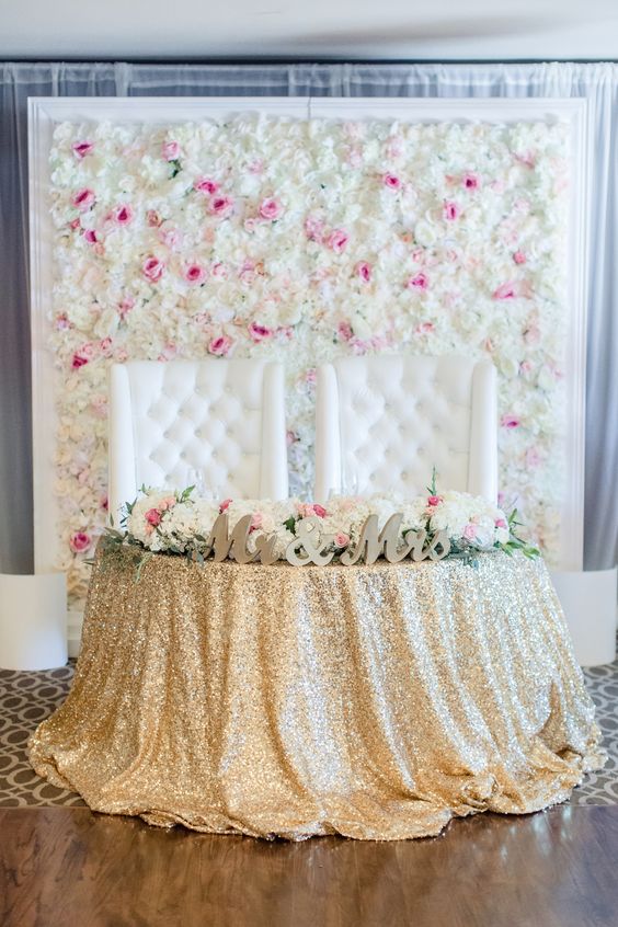 a floral wall of cream and pink blooms in a frame for a refined glam wedding