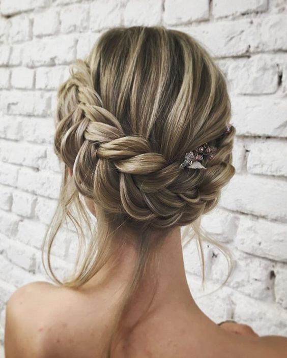 a braided updo with some locks down and a small hairpiece for an accent