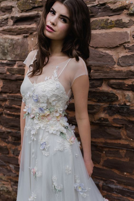 a cute illusion spaghetti strap wedding dress with a sheer top and realistic floral appliques on the whole dress
