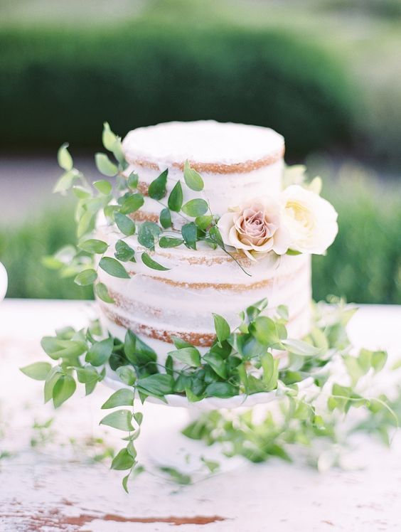 a naked cake with fresh foliage and a couple of neutral blooms for decor