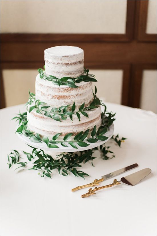 a naked wedding cake with fresh greenery is all you need for a fresh sprign look