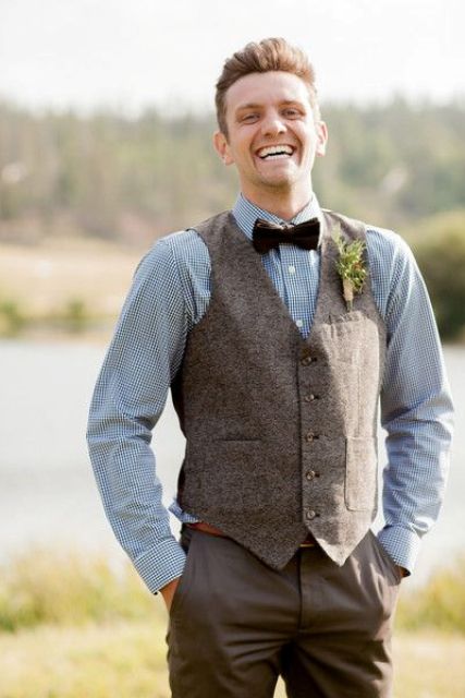 a blue printed button down, tweed vest, brown dress pants, and dark bow tie for a vintage and rustic look