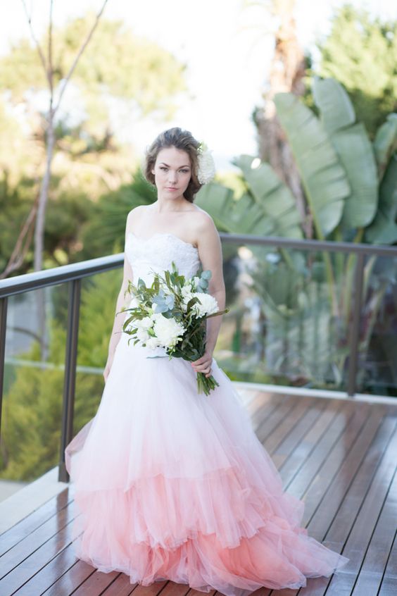 a strapless sweetheart neckline princess-style wedding dress with a ruffled ombre pink skirt