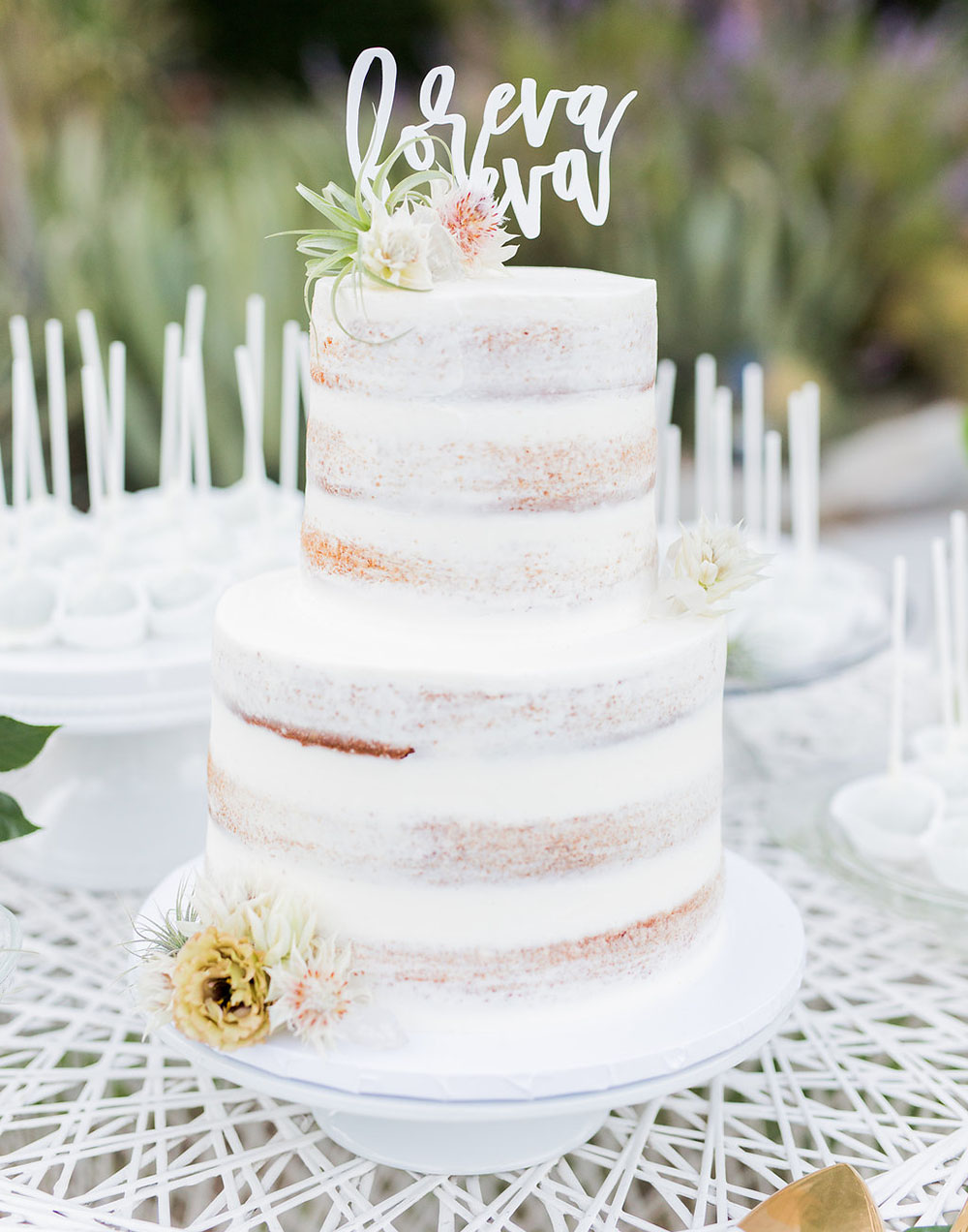 The wedding cake was a naked one with florals and a calligraphy topper
