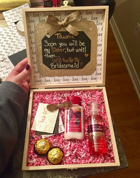 a pink box with glitter touches, chocolate, a body lotion and spray
