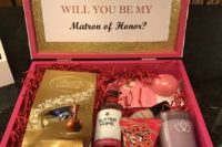 14 a pink box with a candle, a lip balm, some chocolate and a mini alcohol bottle
