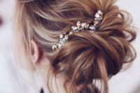 15 a messy updo with a rhinestone hairpiece and some locks down looks effortlessly chic