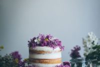 15 a naked cake topped with lilac and some white blooms for a bold spring look