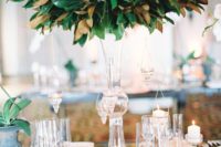 15 a tall crystal vase with a magnolia leaf arrangement is an amazign centerpiece