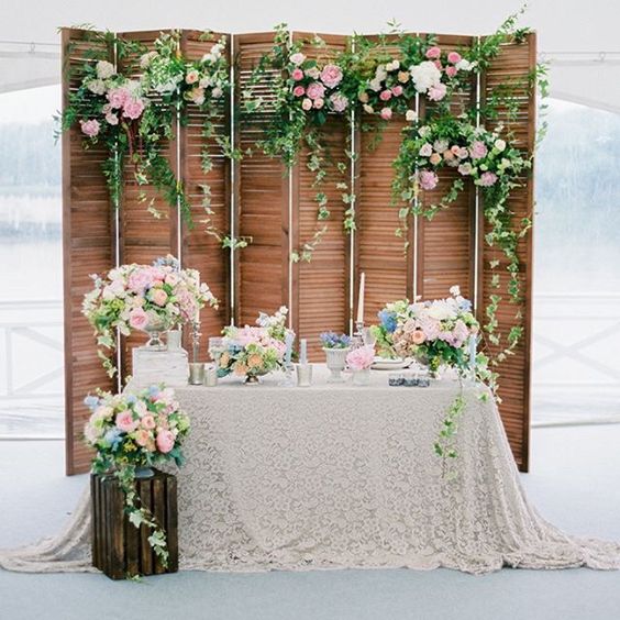 a vintage wooden folding screen with lush greenery and blooms for a refined touch