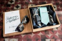 17 a wooden box with a turquoise tie, suspenders, sunglasses and a knife for a dedstination wedding