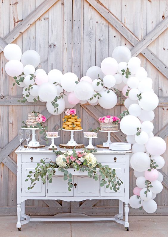 a white balloon and eucalyptus garland for making a dessert table backdrop