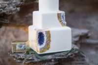 19 a square wedding cake with amethyst and gold leaf decor and a geode on top looks wow