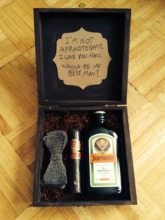 a black box with a cigar, a crocheted bow tie and a small bottle of alcohol