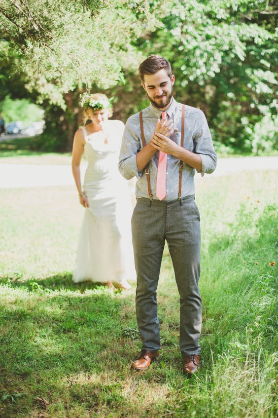 grey pants, a light grey shirt, a pink tie, thin leather suspenders and cognac shoes for a rustic backyard celebration