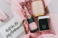 22 a chic and glam bridesmaids’ kit with a necklace, a candle and a bottle of pink champagne