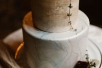 22 a marble wedding cake with light geen and beige layeres and moody blooms