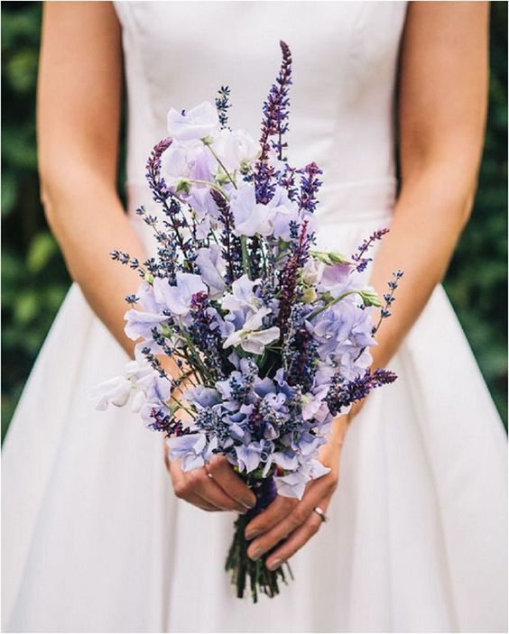 a spring wedding bouquet of lavender and lilac flowers and of a vertical shape looks interesting
