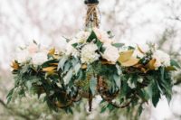22 a stylish rustic chandelier with magnolia leaves, neutral blooms and eucalyptus