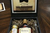 22 a stylish stained wooden box with chocolate, a cigar and a Hennessy bottle