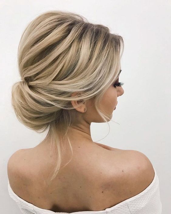 an elegant twisted low bun with a volume on top and some locks down