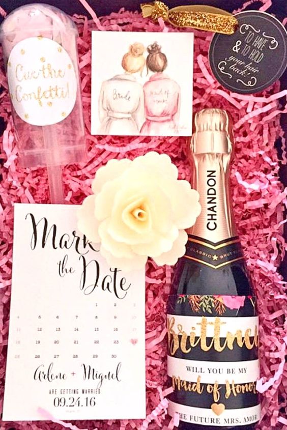 a glam box with a watercolor, confetti, a calendar, a soap flower and a labeled bottle of champagne