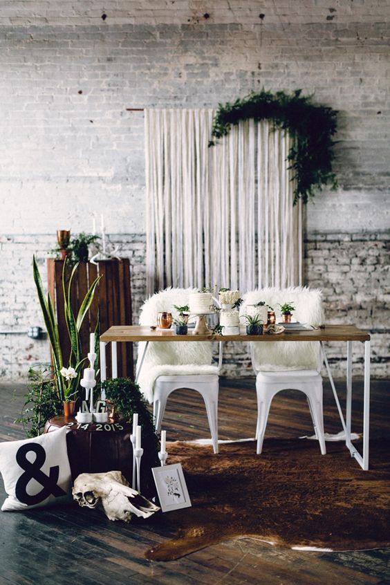 a white fringe backdrop  with lush foliage for a boho-inspired wedding