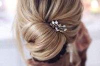 25 a modern elegant bridesmaid’s updo with a low bun, locks down and a rhinestone hairpiece