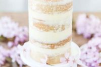 26 a tall and small wedding cake topped with pink cherry blossom