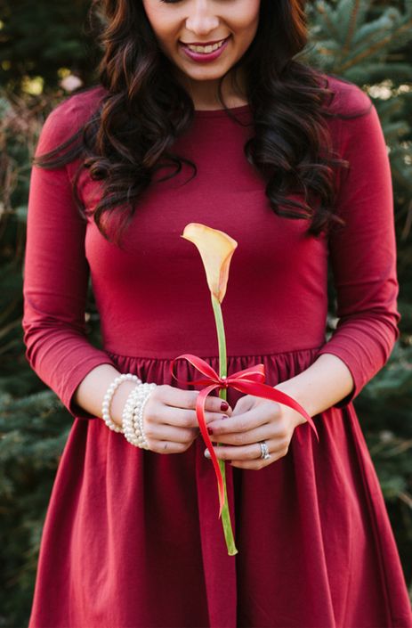 A winter bridesmaid with a single peach colored calla and a red bow on it