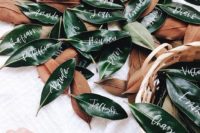 27 magnolia leaves with calligraphy to use them as place or escort cards